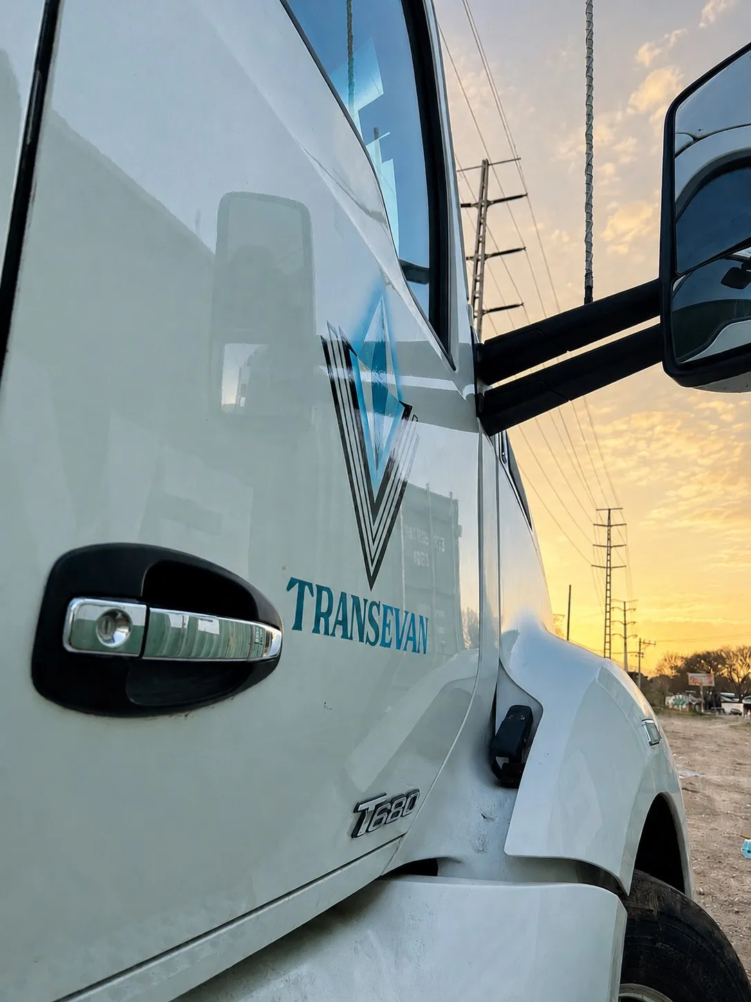 Puerta de un tractocamión Kenworth T680 de TRANSEVAN con el logotipo, al atardecer